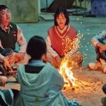 The cast “All of us are Dead” gathered around a fire.